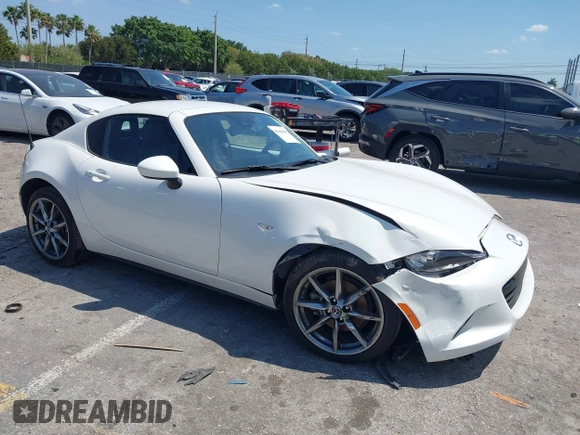 2021 Mazda MX-5 Miata Grand Touring z VIN JM1NDAM75M0450871, wystawiony jako IAAI lot #42060495 z przebiegiem 48 670 mil mil oraz . Historia ofert i sprzedaży dostępna na DreamBid. Obrazek 1.
