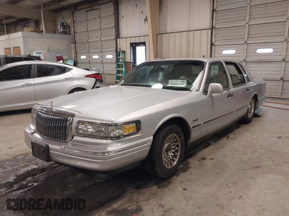 1997 Lincoln Town Car Executive z VIN 1LNLM81W0VY733723, wystawiony jako IAAI lot #41569359 z przebiegiem 104 356 mil mil oraz . Historia ofert i sprzedaży dostępna na DreamBid. Obrazek 2.