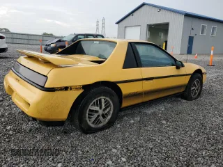 1988 Pontiac Fiero z VIN 1G2PE11R2JP223673, wystawiony jako Copart lot #57300235 z przebiegiem 154 598 mil mil oraz Tytuł czysty. Historia ofert i sprzedaży dostępna na DreamBid. Obrazek 3.