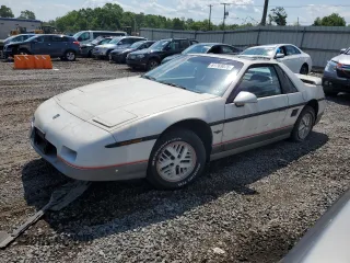1984 Pontiac Fiero z VIN 1G2AF37R3EP250490, wystawiony jako Copart lot #61769075 z przebiegiem Nie podano mil oraz Czysty tytuł • Clean title. Historia ofert i sprzedaży dostępna na DreamBid. Obrazek 1.