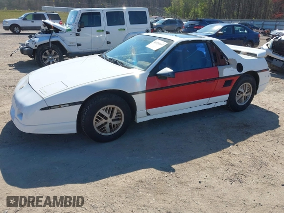 1986 Pontiac Fiero z VIN 1G2PF3790GP231392, wystawiony jako IAAI lot #41870267 z przebiegiem 156 718 mil mil oraz . Historia ofert i sprzedaży dostępna na DreamBid. Obrazek 2.