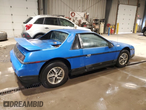 1987 Pontiac Fiero z VIN 1G2PF11R6HP237261, wystawiony jako Copart lot #85061534 z przebiegiem Nie podano mil oraz Czysty tytuł • Clean title. Historia ofert i sprzedaży dostępna na DreamBid. Obrazek 3.