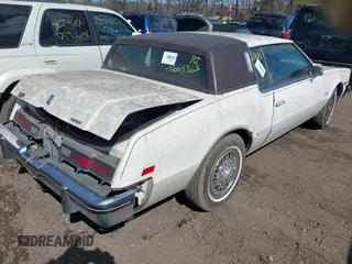 1985 Oldsmobile Toronado Custom Brougham z VIN 1G3EZ57YXFE315260, wystawiony jako IAAI lot #42051171 z przebiegiem Nie podano mil oraz . Historia ofert i sprzedaży dostępna na DreamBid. Obrazek 4.