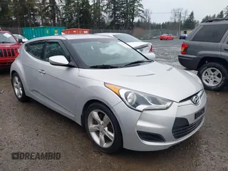 2012 Hyundai Veloster w/Gray Int z VIN KMHTC6ADXCU049689, wystawiony jako IAAI lot #41127697 z przebiegiem 175 985 mil mil oraz . Historia ofert i sprzedaży dostępna na DreamBid. Obrazek 1.