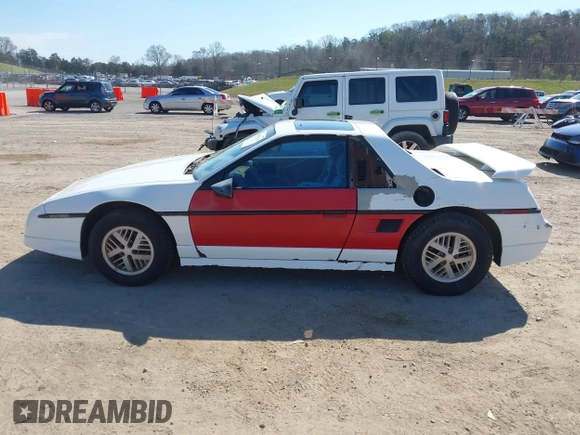 1986 Pontiac Fiero z VIN 1G2PF3790GP231392, wystawiony jako IAAI lot #41870267 z przebiegiem 156 718 mil mil oraz . Historia ofert i sprzedaży dostępna na DreamBid. Obrazek 14.