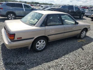 1991 Toyota Camry DLX z VIN 4T1SV21E5MU415356, wystawiony jako Copart lot #74465914 z przebiegiem 74 592 mil mil oraz Szkoda całkowita • Salvage title. Historia ofert i sprzedaży dostępna na DreamBid. Obrazek 3.