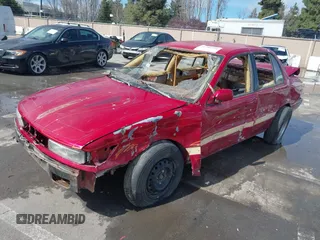 1990 Mitsubishi Mirage z VIN JA3CU26X2LU049259, wystawiony jako IAAI lot #41788912 z przebiegiem Nie podano mil oraz . Historia ofert i sprzedaży dostępna na DreamBid. Obrazek 2.