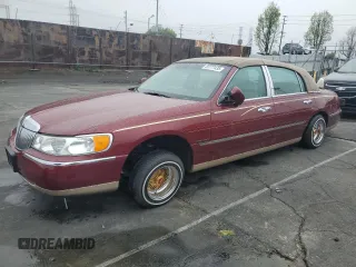 1999 Lincoln Town Car Signature z VIN 1LNHM82W7XY612906, wystawiony jako Copart lot #50777435 z przebiegiem 110 414 mil mil oraz Szkody całkowita. Historia ofert i sprzedaży dostępna na DreamBid. Obrazek 1.