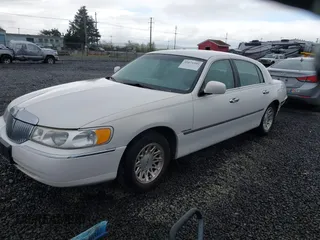 1999 Lincoln Town Car Signature z VIN 1LNFM82W0XY603679, wystawiony jako IAAI lot #41871509 z przebiegiem 109 638 mil mil oraz . Historia ofert i sprzedaży dostępna na DreamBid. Obrazek 2.