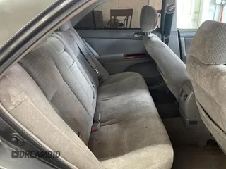 2002 Toyota Camry LE z VIN 4T1BE30K52U542523, wystawiony jako Copart lot #57983805 z przebiegiem 264 137 mil mil oraz Czysty tytuł • Clean title. Historia ofert i sprzedaży dostępna na DreamBid. Obrazek 6.