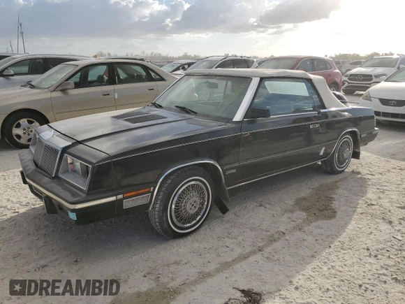 1985 Chrysler LeBaron Mark Cross z VIN 1C3BC55E0FG160918, wystawiony jako Copart lot #76659284 z przebiegiem Nie podano mil oraz Szkody całkowita. Historia ofert i sprzedaży dostępna na DreamBid. Obrazek 1.