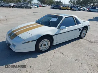 1986 Pontiac Fiero z VIN 1G2PF3797GP269850, wystawiony jako IAAI lot #40722755 z przebiegiem 129 077 mil mil oraz . Historia ofert i sprzedaży dostępna na DreamBid. Obrazek 2.