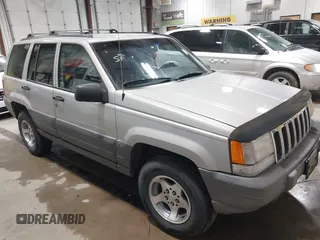 1996 Jeep Grand Cherokee Laredo z VIN 1J4GZ58S5TC293897, wystawiony jako IAAI lot #42435233 z przebiegiem 167 432 mil mil oraz . Historia ofert i sprzedaży dostępna na DreamBid. Obrazek 1.