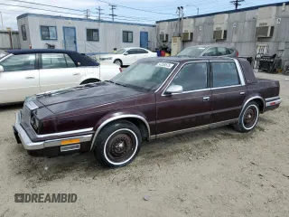 1989 Chrysler New Yorker z VIN 1C3BC6633KD635296, wystawiony jako Copart lot #54358575 z przebiegiem 14 770 mil mil oraz Tytuł czysty. Historia ofert i sprzedaży dostępna na DreamBid. Obrazek 1.