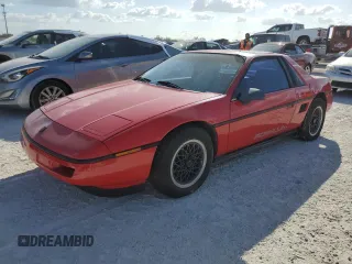 1988 Pontiac Fiero z VIN 1G2PE11R1JP219470, wystawiony jako Copart lot #77772864 z przebiegiem 94 011 mil mil oraz Szkody całkowita. Historia ofert i sprzedaży dostępna na DreamBid. Obrazek 1.