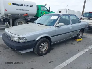 1990 Toyota Camry z VIN 4T1SV24E0LU190211, wystawiony jako IAAI lot #42368986 z przebiegiem 145 167 mil mil oraz . Historia ofert i sprzedaży dostępna na DreamBid. Obrazek 2.