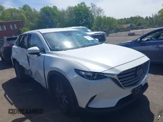 2021 Mazda CX-9 Touring z VIN JM3TCBCYXM0521323, wystawiony jako IAAI lot #42190976 z przebiegiem 56 652 mil mil oraz . Historia ofert i sprzedaży dostępna na DreamBid. Obrazek 1.