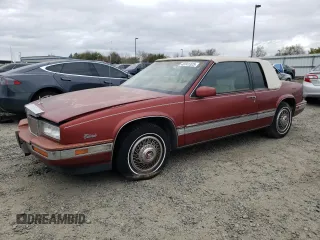 1986 Cadillac Eldorado z VIN 1G6EL5784GU616263, wystawiony jako Copart lot #48741325 z przebiegiem 59 213 mil mil oraz Tytuł czysty. Historia ofert i sprzedaży dostępna na DreamBid. Obrazek 1.