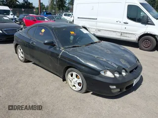 2000 Hyundai Tiburon z VIN KMHJG35F5YU191588, wystawiony jako IAAI lot #41934653 z przebiegiem 161 590 mil mil oraz . Historia ofert i sprzedaży dostępna na DreamBid. Obrazek 1.