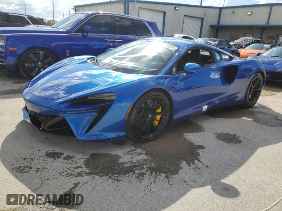 2024 McLaren Artura z VIN SBM16AEA2RW002389, wystawiony jako Copart lot #74246334 z przebiegiem 1374 mil mil oraz Nie do naprawy. Historia ofert i sprzedaży dostępna na DreamBid. Obrazek 1.