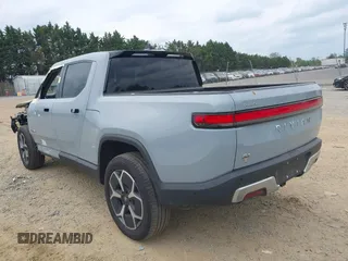 2023 Rivian R1T Adventure z VIN 7FCTGBAA6PN028520, wystawiony jako IAAI lot #42117498 z przebiegiem 24 583 mil mil oraz . Historia ofert i sprzedaży dostępna na DreamBid. Obrazek 3.