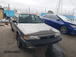1990 Toyota Camry DLX z VIN 4T1SV21E7LU248206, wystawiony jako IAAI lot #41793635 z przebiegiem 83 550 mil mil oraz . Historia ofert i sprzedaży dostępna na DreamBid. Obrazek 1.