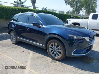 2021 Mazda CX-9 Grand Touring z VIN JM3TCBDY6M0526212, wystawiony jako IAAI lot #42432569 z przebiegiem 50 142 mil mil oraz . Historia ofert i sprzedaży dostępna na DreamBid. Obrazek 1.