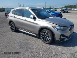 2021 BMW X1 sDrive28i z VIN WBXJG7C09M5U26043, wystawiony jako IAAI lot #36062187 z przebiegiem 14 844 mil mil oraz . Historia ofert i sprzedaży dostępna na DreamBid. Obrazek 1.