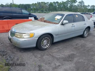 2000 Lincoln Town Car Signature z VIN 1LNHM82W3YY859857, wystawiony jako IAAI lot #42495876 z przebiegiem Nie podano mil oraz . Historia ofert i sprzedaży dostępna na DreamBid. Obrazek 2.