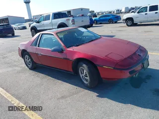 1987 Pontiac Fiero z VIN 1G2PE11R3HP239147, wystawiony jako IAAI lot #42533471 z przebiegiem 71 459 mil mil oraz . Historia ofert i sprzedaży dostępna na DreamBid. Obrazek 1.