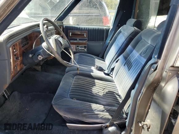 1988 Cadillac Brougham z VIN 1G6DW51Y2J9714052, wystawiony jako Copart lot #77274064 z przebiegiem 69 106 mil mil oraz Szkoda całkowita • Salvage title. Historia ofert i sprzedaży dostępna na DreamBid. Obrazek 7.