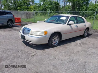 2001 Lincoln Town Car Cartier z VIN 1LNHM83W81Y688740, wystawiony jako IAAI lot #42526475 z przebiegiem 256 179 mil mil oraz . Historia ofert i sprzedaży dostępna na DreamBid. Obrazek 2.