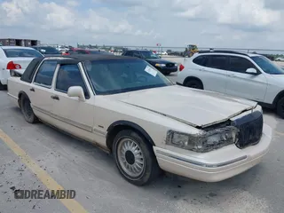1997 Lincoln Town Car Cartier z VIN 1LNLM83W8VY627663, wystawiony jako IAAI lot #42392454 z przebiegiem 209 440 mil mil oraz . Historia ofert i sprzedaży dostępna na DreamBid. Obrazek 1.