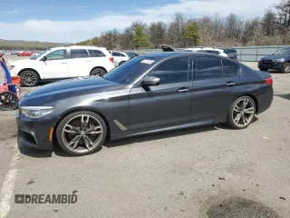 2018 BMW 5 Series M550i xDrive with VIN WBAJB9C57JB286734, listed as a Copart auction lot 52711235 with 127,450 mi miles and Salvage title. Bid and sale history available at DreamBid. Image 1.
