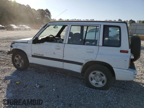 1997 Geo Tracker LSi z VIN 2CNBE1360V6927915, wystawiony jako Copart lot #53469605 z przebiegiem 119 413 mil mil oraz Szkoda całkowita • Salvage title. Historia ofert i sprzedaży dostępna na DreamBid. Obrazek 2.